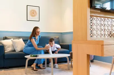 a woman and a young boy sitting in a living room at La Villa Boutique Hotel in Budva