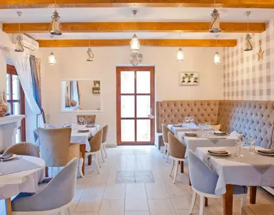 a restaurant with tables and chairs and a window at La Villa Boutique Hotel in Budva