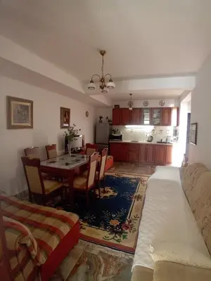 a living room with a table and a kitchen at Olga Bashinskaya in Sutomore