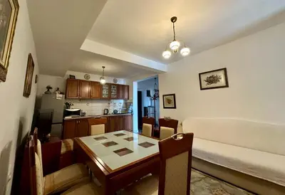 a living room with a dining room table and a kitchen at Olga Bashinskaya in Sutomore