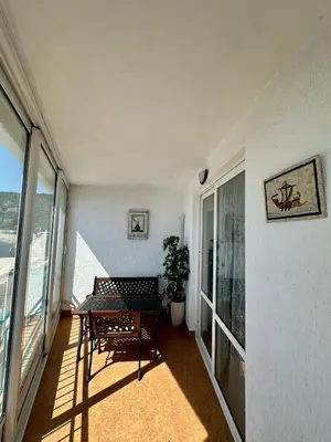 a balcony with a table in a room with windows at Olga Bashinskaya in Sutomore