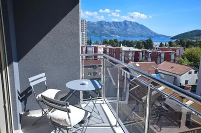 a balcony with a table and chairs on a building at Apartment Bojana in Budva