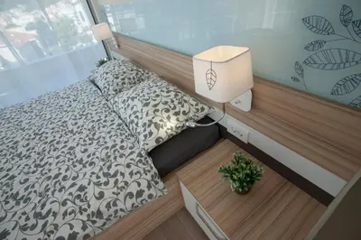 a small bedroom with a bed and a lamp at JK Suites in Budva