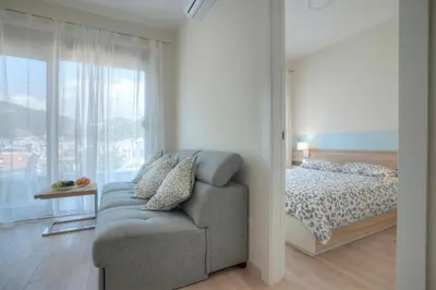 a bedroom with a couch and a bed and a window at JK Suites in Budva