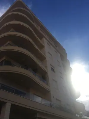 a tall building with the sun in the sky at JK Suites in Budva
