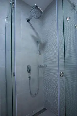 a shower with a glass door and a shower head at JK Suites in Budva