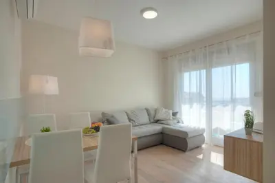 a white living room with a couch and a table at JK Suites in Budva