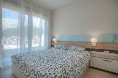 a bedroom with a bed and a large window at JK Suites in Budva