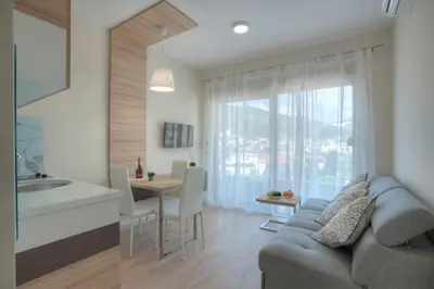 a kitchen and living room with a couch and a table at JK Suites in Budva