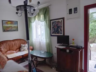 a living room with a chair and a desk with a computer at Apartment Botanicheskiy Sad in Sutomore