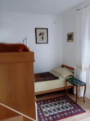 a small bedroom with a bed and a table at Apartment Botanicheskiy Sad in Sutomore