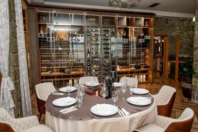 a table in a room with a wine cellar at Hotel Aria in Podgorica
