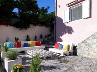 a patio with two benches with colorful pillows at Maritimo Apartments in Kotor