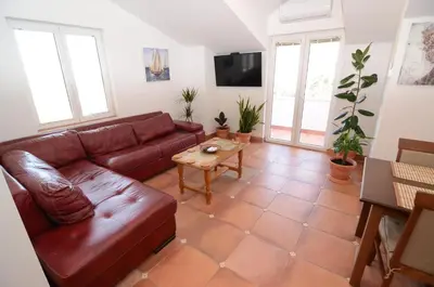 a living room with a brown leather couch and a table at Maritimo Apartments in Kotor