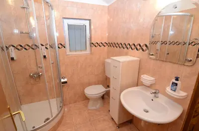 a bathroom with a toilet and a shower and a sink at Maritimo Apartments in Kotor