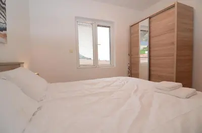 a white bed in a bedroom with a window at Maritimo Apartments in Kotor