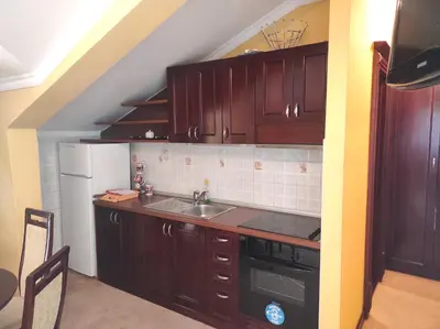a kitchen with wooden cabinets and a sink at Hotel Mimoza in Budva
