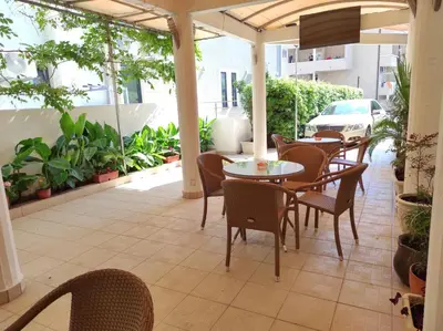 an outdoor patio with tables and chairs and plants at Hotel Mimoza in Budva