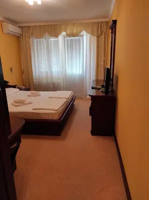 a bedroom with two beds and a television in it at Hotel Mimoza in Budva