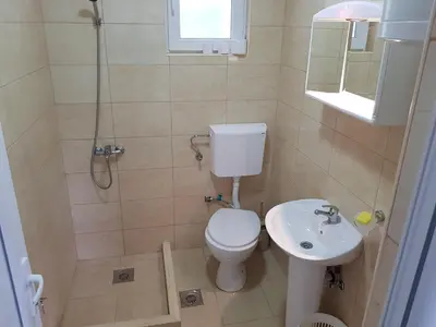 a bathroom with a toilet and a shower and a sink at Apartmani Vila Ebra in Utjeha