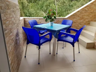 a blue table and chairs on a balcony at Apartmani Vila Ebra in Utjeha