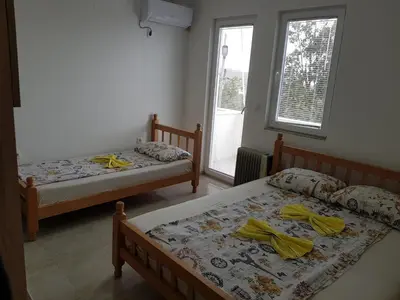 two beds in a room with two windows at Apartmani Vila Ebra in Utjeha