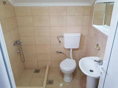 a bathroom with a toilet and a sink at Apartmani Vila Ebra in Utjeha