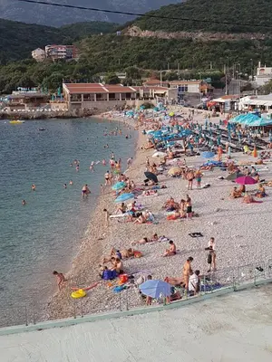a bunch of people on a beach in the water at Apartmani Vila Ebra in Utjeha