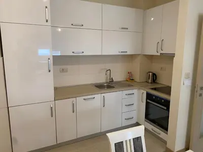 a kitchen with white cabinets and a sink at Apartments New City in Podgorica