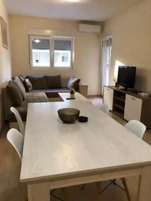 a living room with a table and a couch at Apartments New City in Podgorica