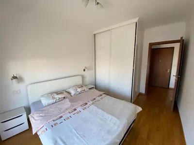 a bedroom with a large bed and a closet at Apartments New City in Podgorica