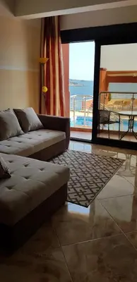 a living room with a couch and a view of the ocean at Apartment Sea Space 2 in Dobra Voda