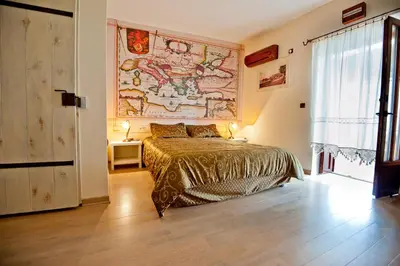 a bedroom with a bed and a large painting on the wall at Medin di Lastua in Petrovac na Moru