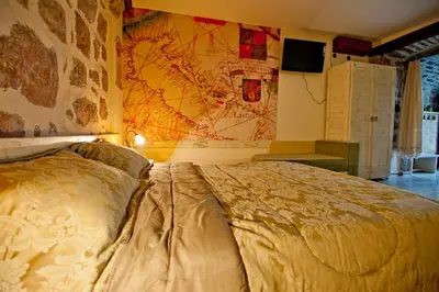 a bedroom with a large bed with a map on the wall at Medin di Lastua in Petrovac na Moru