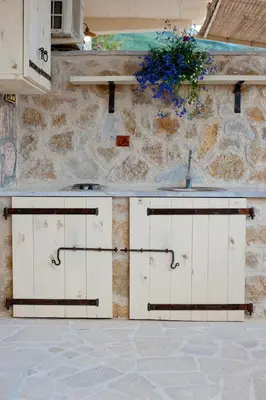 two white doors on a building with a stone wall at Medin di Lastua in Petrovac na Moru