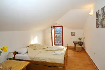 a bedroom with a bed and a table at Loki Apartments in Kotor