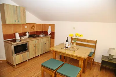 a kitchen with a wooden table and a table and chairs at Loki Apartments in Kotor