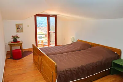 a bedroom with a bed and a large window at Loki Apartments in Kotor
