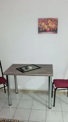 a wooden table with a picture on the wall at Apartments Petrovic in Krimovice