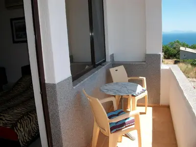 a balcony with two chairs and a table and a window at Apartments Petrovic in Krimovice