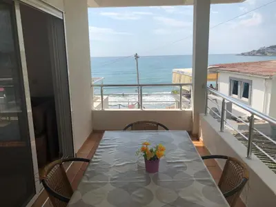 a table on a balcony with a view of the ocean at Casa Mila apartments & bungalows in Ulcinj