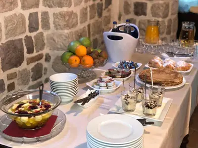 a table with plates of food and fruit on it at Hotel Monte Cristo in Kotor