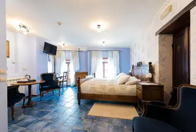 a bedroom with a bed and a table and chairs at Hotel Monte Cristo in Kotor