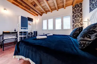 a bedroom with a large bed and a desk at Oasis Seaside Rooms in Budva