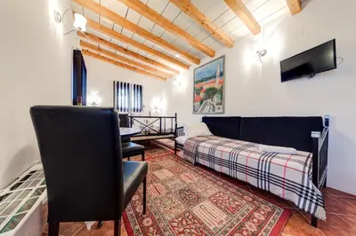 a bedroom with a bed and a desk and a tv at Oasis Seaside Rooms in Budva