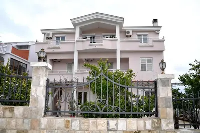 a white house with a black fence at Apartments Perezaj in Ulcinj