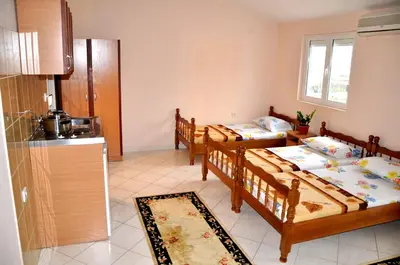 two beds in a room with a kitchen at Apartments Perezaj in Ulcinj