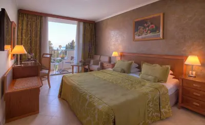 a hotel room with a bed and a balcony at Mediteran Hotel & Resort in Budva
