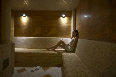 a woman sitting on a couch in a room at Mediteran Hotel & Resort in Budva