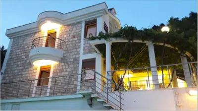 a house with a balcony with lights on it at Budva City - Villa Antic - Private Pool in Budva